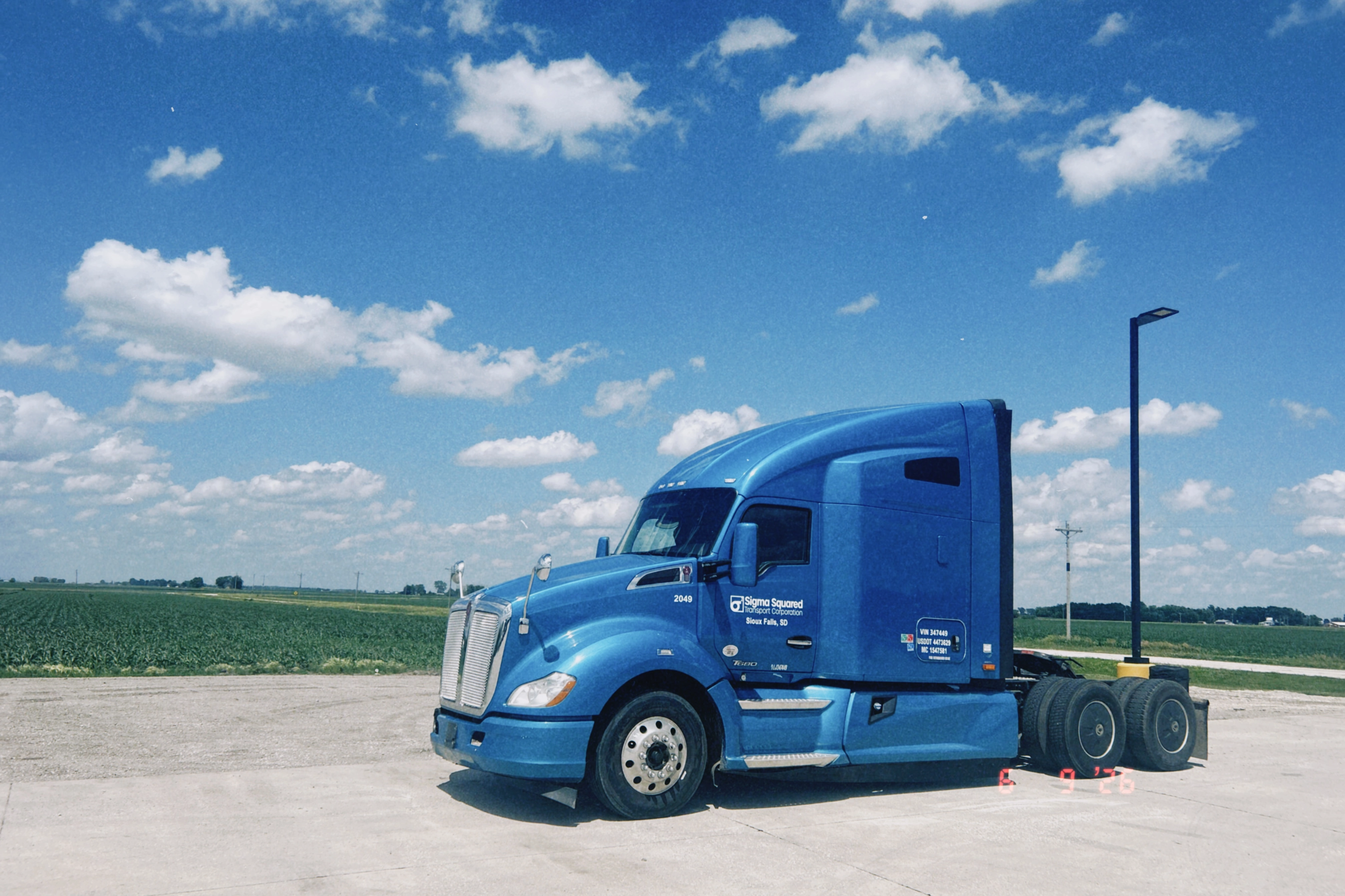 Blue Sigma Squared truck parked under a bright sky